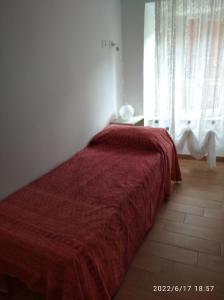 - une chambre avec un lit et une couverture rouge dans l'établissement Appartamento arredato Segni Roma CASA ANNA MARIA, à Segni