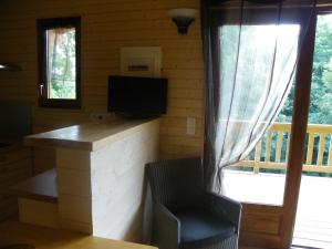 Habitación con escritorio y TV en una cabina. en Le Chalet du Chloris, en Saint-Maxire
