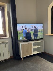 a flat screen tv sitting on top of a cabinet at Studio de charme au coeur de Valréas in Valréas