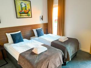 2 łóżka w pokoju hotelowym z ręcznikami w obiekcie Apartamenty Centrum Park Twardowskiego 4 w Zielonej Górze