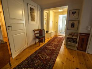 a hallway with a door and a chair and a rug at Villa Lövkulla with Sauna in Löparö