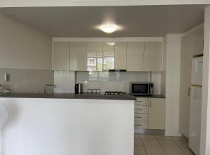 a kitchen with white cabinets and a counter top at Westmead Home away from home in Westmead