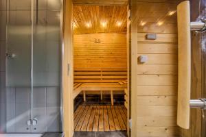 a walk in shower in a wooden room with a sauna at VisitZakopane - Diamond Spa Apartment in Zakopane