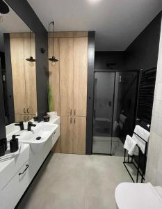 łazienka z 2 umywalkami i prysznicem w obiekcie Niezapominajka przy Manufakturze w Łodzi