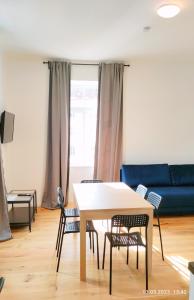 a living room with a table and chairs and a blue couch at Krems am Campus in Krems an der Donau