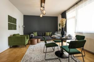 Bright stylish apartment with a huge terrace in a top location في فيينا: غرفة معيشة مع أريكة وطاولة وكراسي