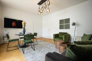 Bright stylish apartment with a huge terrace in a top location في فيينا: غرفة معيشة مع طاولة وكراسي خضراء