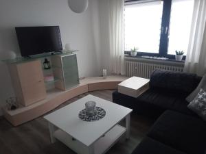 sala de estar con sofá y TV en Ahrtal Flair, en Bad Neuenahr-Ahrweiler