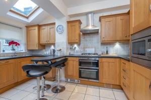 a kitchen with wooden cabinets and a black counter top at Sleeps 5 - 3 Bedrooms - walk to the square hosted Happy Valley cast in Hebden Bridge