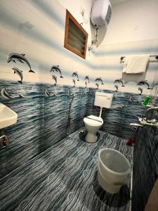 baño con un mural de delfines en la pared en Oneness nest, en Yercaud