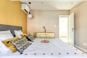 Un dormitorio con una gran cama blanca con corazones rojos. en Les Clés de Laure - Le 11 JACUZZI avec Terrasses Clim Netflix Parking, en Carcassonne