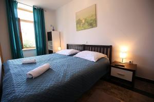 ein Schlafzimmer mit einem Bett mit zwei Handtüchern darauf in der Unterkunft Apartments Stadthaus Briski in Opatija