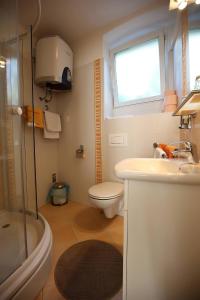 ein Bad mit einem Waschbecken, einem WC und einem Fenster in der Unterkunft Apartments Stadthaus Briski in Opatija