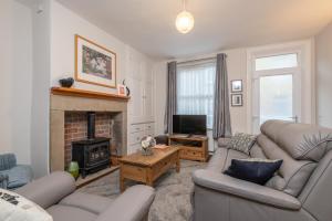 a living room with two couches and a fireplace at Sleeps 5 - 3 Bedrooms - walk to the square hosted Happy Valley cast in Hebden Bridge