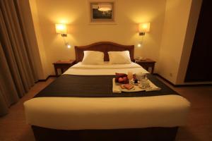 a hotel room with a bed and a dresser at Hotel da Bolsa in Porto