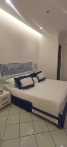 ein großes Bett in einem Zimmer mit weißem Boden in der Unterkunft Hotel Bristol in Vietri