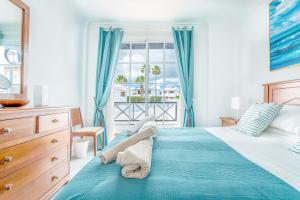 a bedroom with a bed with blue curtains and a window at Casa Laura in Puerto del Carmen