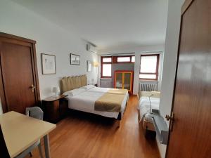 Schlafzimmer mit einem Bett, einem Schreibtisch und einem Tisch in der Unterkunft Maison Giolitti in Turin