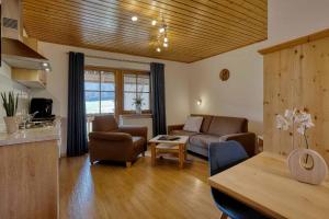 a living room with a couch and a table at Ferienwohnungen Holzferienhäuser Leithenwald in Zwiesel