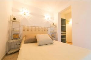 a bedroom with a bed with two lights on the wall at Appartement T2 rez de villa in Saint-Florent