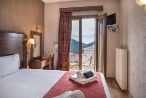 a hotel room with a bed and a balcony at Arahova Inn Hotel in Arachova