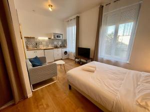 sypialnia z łóżkiem i krzesłem oraz kuchnia w obiekcie A1D Studio Nancy Thermal ARTEM w Nancy +2 zdjęcia