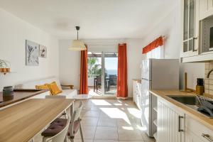 a kitchen with white cabinets and a table with a sink at Casa con vistas al Mar y Piscinas 7 in Roses