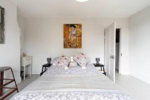 um quarto branco com uma cama grande e almofadas em Heart of the beautiful Old Town em Hastings mais 3 fotografias