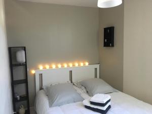 Un dormitorio con una cama blanca con luces. en Le petit gite Bio du Rhôny, en Le Cailar