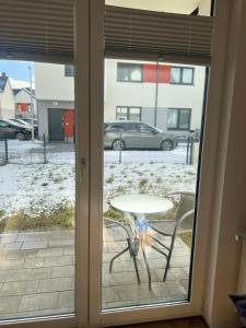 a table and chairs in front of a sliding glass door at Uroczy apartament z ogrodem in Rumia