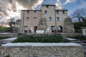 ein altes Steingebäude mit einer Steinmauer in der Unterkunft DOLF - Porta Gemina - Intera Villa in San Crocifisso