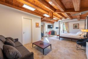 ein Wohnzimmer mit einem Sofa und einem Bett in der Unterkunft DOLF - Porta Gemina - Intera Villa in San Crocifisso