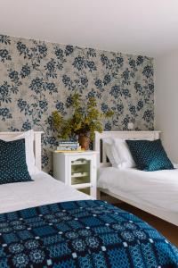 a bedroom with two beds with blue and white sheets at The Red Barn at Venn Farm - Gorgeous Upside-Down Barn on Smallholding Near Cornish Surf Beaches in Bude