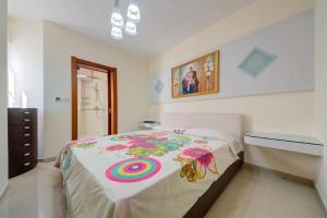 una camera da letto con un grande letto con una coperta colorata di Amazing 1 bedroom with views in Mellieha a Mellieħa