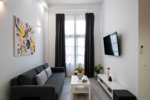 a living room with a couch and a window at Central Suites Aegina 1 in Egina