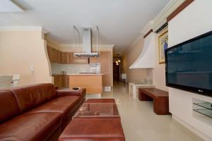 un soggiorno con divano e grande TV di Amazing 1 bedroom with views in Mellieha a Mellieħa
