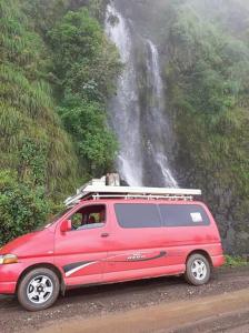 a red van parked in front of a waterfall at King Dawit Ethiopia Tours & Travel in Addis Ababa