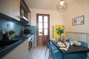 a kitchen with a table and blue chairs in a room at Lemon Garden House in San Miniato Basso