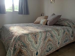 ein Bett mit zwei Kissen darauf in einem Schlafzimmer in der Unterkunft DEPARTAMENTOS LEMOS TRES in Mendoza