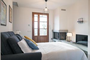 a bedroom with a bed and a couch and a fireplace at Lemon Garden House in San Miniato Basso