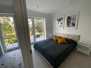 a bedroom with a bed with yellow pillows on it at Kemény Klára Parti Háza in Zamárdi