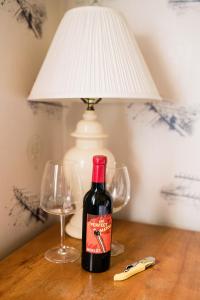 una bottiglia di vino seduta su un tavolo con due bicchieri di Fox & Bear Lodge a Glenwood
