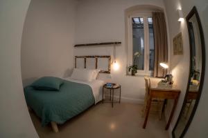 um quarto com uma cama, uma mesa e uma janela em B&B Murex em Bari