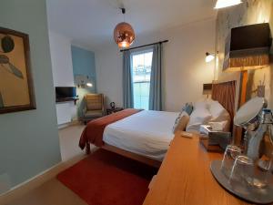 a hotel room with a bed and a desk with a table at Browns Hotel in Dartmouth