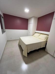 a bedroom with a bed with a red and white wall at Lindo apartamento no Setor Bueno- todo reformado - tudo novinho -Sua busca termina aqui in Goiânia