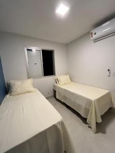 a room with two beds and a window at Lindo apartamento no Setor Bueno- todo reformado - tudo novinho -Sua busca termina aqui in Goiânia