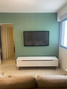a living room with a flat screen tv on a wall at Lindo apartamento no Setor Bueno- todo reformado - tudo novinho -Sua busca termina aqui in Goiânia