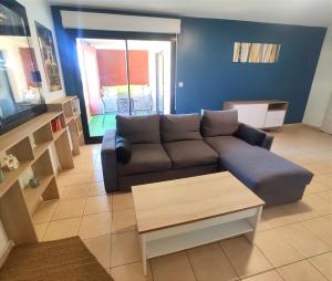 salon z kanapą i stołem w obiekcie Le Dory - Appartement Centre Ville avec Terrasse, Parking & Wifi w Montpellier