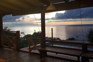 莱昂斯-达赫雷VILLA COCO ROSE的门廊享有海景,设有长凳