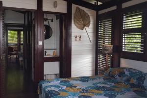 1 dormitorio con 1 cama en una habitación con ventanas en VILLA COCO ROSE, en Les Anses-dʼArlet
